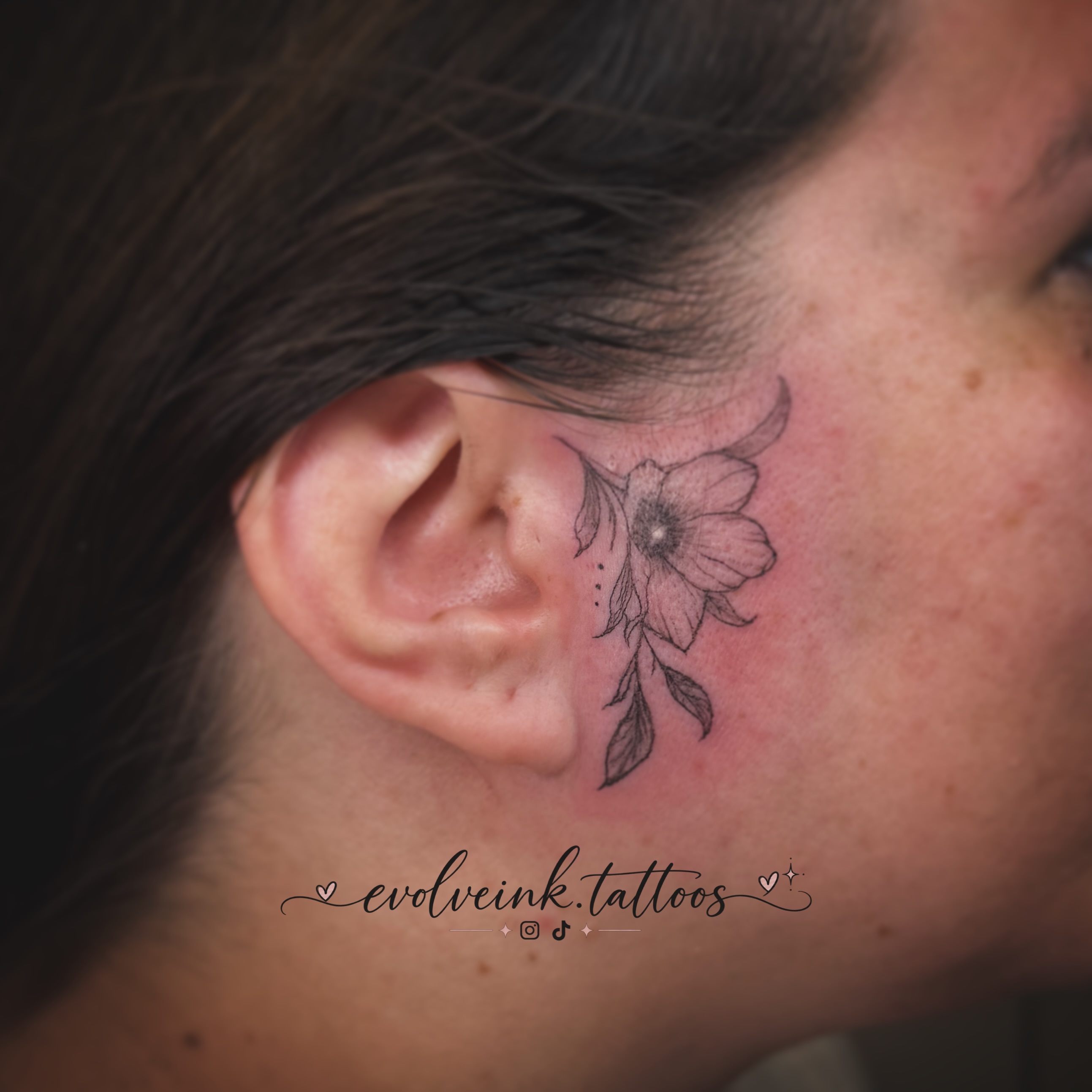 Kelsey’s fine-line floral tattoo following the curve of an ear