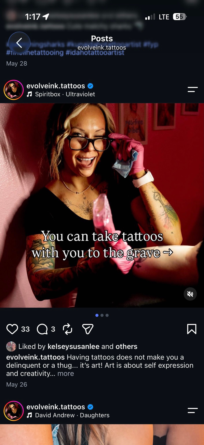 Kelsey smiling in her studio, wearing glasses and pink tattoo gloves
